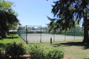 a tennis court with a fence and a tennis court at Da Praia Apartment - Pool & Tenis in Vilamoura