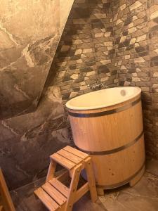 La salle de bains est pourvue d'une baignoire en bois et d'un tabouret en bois. dans l'établissement Tatrzański Domek & SPA, à Poronin