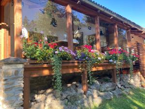 un portico in legno con fiori in giardino di Penzion Na Habeši a Kašperské Hory