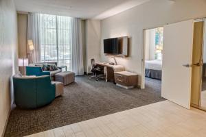 ein Hotelzimmer mit einem Schlafzimmer mit einem Bett und einem Schreibtisch in der Unterkunft Courtyard by Marriott Dulles Airport Herndon in Herndon