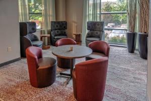 Zimmer mit Stühlen, einem Tisch, einem Tisch und Stühlen in der Unterkunft Courtyard by Marriott Dulles Airport Herndon in Herndon