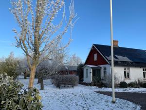 czerwono-biały dom z pokrytym śniegiem dziedzińcem w obiekcie Villa Maria Garden Cottages, Helsingborg w mieście Helsingborg