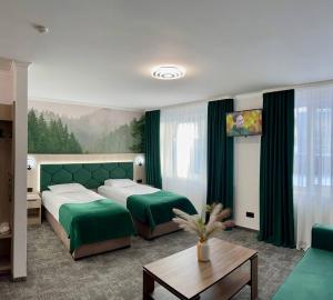 a hotel room with two beds and a table at Prykarpattya in Ivano-Frankivsʼk