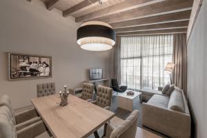 a living room with a table and a couch at Gardena Grödnerhof - Hotel & Spa in Ortisei