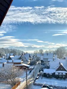 un villaggio ricoperto di neve con un cielo azzurro di Pokoje z własnymi aneksami kuchennymi - Zbigniew Lassak a Biały Dunajec