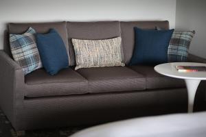 ein braunes Sofa mit blauen Kissen und einem Tisch in der Unterkunft Marriott Dallas Las Colinas in Irving