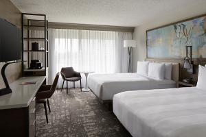 ein Hotelzimmer mit 2 Betten und einem Schreibtisch in der Unterkunft Marriott Dallas Las Colinas in Irving