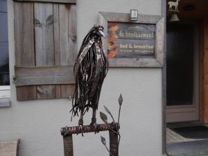 a bird perched on the arm of a metal fence at B&B Le bruissement in Bièvre