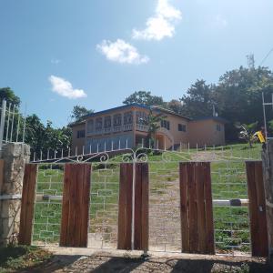 ein Tor vor einem Haus auf einem Feld in der Unterkunft Mango walk homestay in Montego Bay