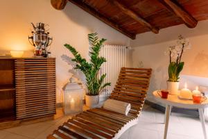 een kamer met een stoel en een tafel met planten bij Villa Romantica Wellness & SPA in Lucca