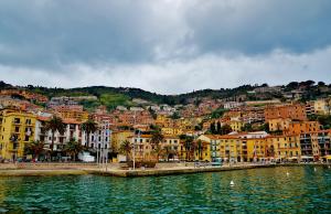 een groep gebouwen op een heuvel naast een waterlichaam bij Appartamento Onda d'argento in Porto Santo Stefano