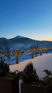 un champ enneigé avec des lumières au loin dans l'établissement Yo Hotel, à Bukovel