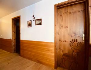 Habitación con una puerta de madera con un ciervo pintado. en Charlotte Lodge Cervinia, en Breuil-Cervinia