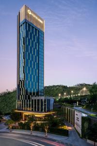 um edifício alto com luzes em cima em The G Shenzhen, A Tribute Portfolio Hotel em Shenzhen