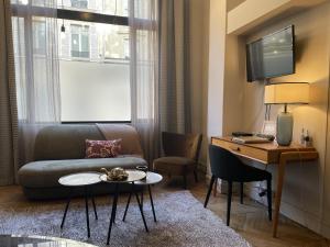 een woonkamer met een bank, een tafel en een bureau bij Loft Royal des Promenades in Reims