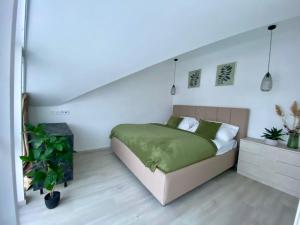 a bedroom with a bed with a green bedspread at Loft Vrchlabí in Vrchlabí