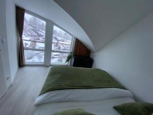 a bedroom with a bed and a large window at Loft Vrchlabí in Vrchlabí