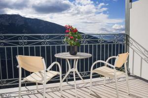 un balcón con 2 sillas y una mesa con una flor en V Hotel Delphi, en Delfos