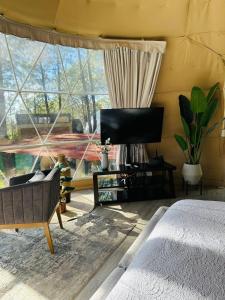 1 dormitorio con cama y ventana grande en Tres Lunas Domo, en Mazamitla