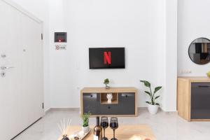 een woonkamer met een tv met de letter n op de muur bij New Luxury Apartment in Downtown in Thessaloniki