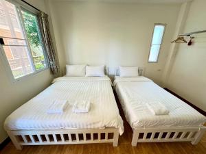 2 camas individuais num quarto com uma janela em Rak Na Khaoyai em Mu Si