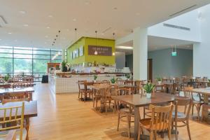 ein Restaurant mit Holztischen und -stühlen und einer Theke in der Unterkunft Changi Cove in Singapur