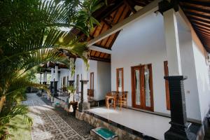 uma casa com paredes brancas e um tecto de madeira em The Dagan Bungalow em Nusa Penida