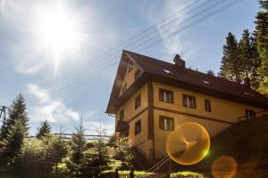 un bâtiment avec le soleil dans le ciel dans l'établissement Willa Arga, à Piwniczna-Zdrój