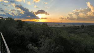 Villa Toscana I - Gran Vista y Tranquilidad في فيلا سيرانا: غروب الشمس على غابة من الأشجار مع غروب الشمس