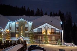 a large building with christmas lights on it at night at MK Resort (ex. Magiya Karpat) in Bukovel