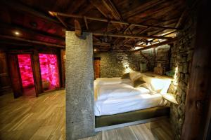 a bedroom with a bed in a stone building at Café Quinson Relais de Charme in Morgex