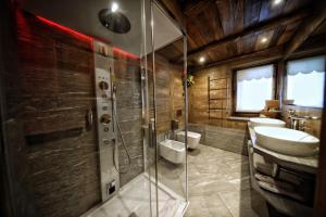 a bathroom with a shower and two sinks and a toilet at Café Quinson Relais de Charme in Morgex