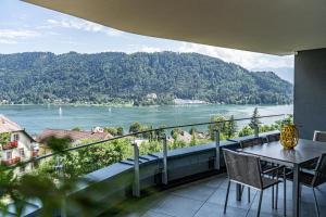 安嫩海姆Top 21 Alpe Maritima - Feriendomizil am Ossiachersee mit Seeblick的阳台配有桌椅,享有河景