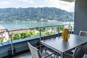 安嫩海姆Top 21 Alpe Maritima - Feriendomizil am Ossiachersee mit Seeblick的河景阳台配有桌椅