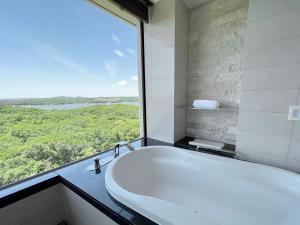 y baño con bañera y ventana grande. en Shima Kanko Hotel The Bay Suites, en Shima