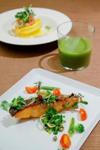 een bord eten op een tafel met een glas groen sap bij MUWA NISEKO in Kutchan