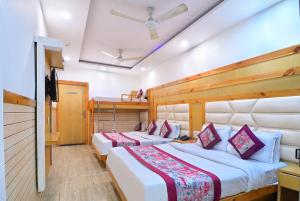 um quarto de hotel com duas camas e uma televisão em Hotel Glow Inn Paharganj-3 Mins Walk From New Delhi Railway Station em Nova Deli