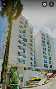 a large apartment building with a palm tree in front of it at EXCELENTE CONJUNTO, UBICACION PRIVILEGIADA, in Armenia