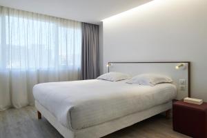 Tempat tidur dalam kamar di Hotel-Restaurant Isidore Nice Ouest