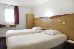 Tempat tidur dalam kamar di Hotel-Restaurant Isidore Nice Ouest