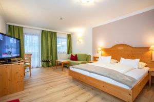 A bed or beds in a room at Hotel Oberwirt - nahe an Saalbach und Zell am See