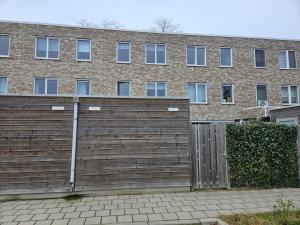 多德雷赫特Residence Dordrecht - 10 persons的砖楼前的木栅