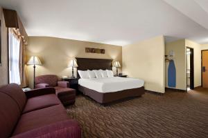 ein Hotelzimmer mit einem Bett und einem Sofa in der Unterkunft Best Western Center Pointe Inn in Branson