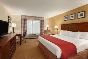 um quarto de hotel com uma cama grande e uma secretária em Country Inn & Suites by Radisson, Ames, IA em Ames