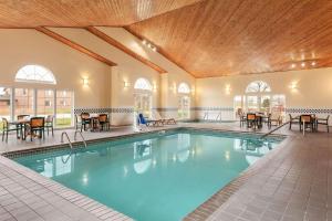 uma piscina num hotel com mesas e cadeiras em Country Inn & Suites by Radisson, Ames, IA em Ames