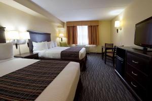 Country Inn & Suites by Radisson, Niagara Falls, ON tesisinde bir odada yatak veya yataklar