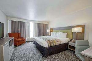 una camera d'albergo con letto e sedia di Country Inn & Suites by Radisson, New Orleans I-10 East, LA a New Orleans