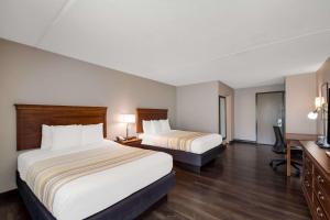 a hotel room with two beds and a desk at Country Inn & Suites by Radisson, Fredericksburg South I-95 , VA in Fredericksburg