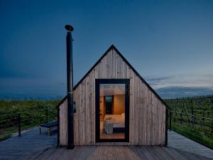 Cette petite maison en bois dispose d'un lit sur une terrasse. dans l'établissement CAMPY ECO HOUSE • EGER, à Ostoros