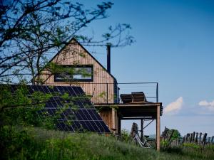 une grange avec des panneaux solaires et une maison dans l'établissement CAMPY ECO HOUSE • EGER, à Ostoros